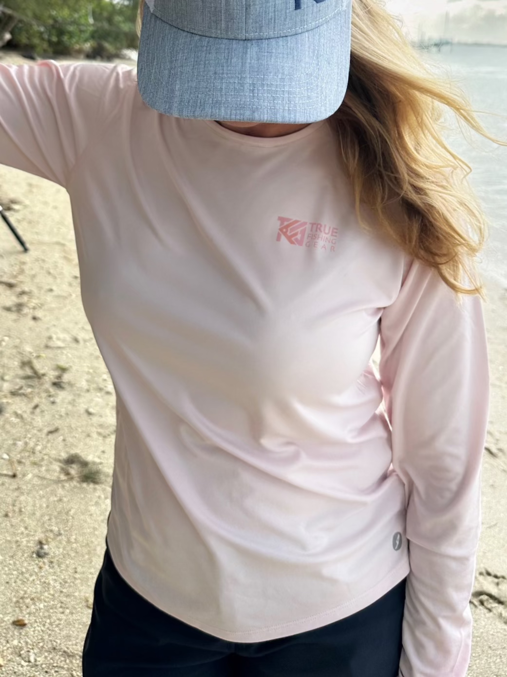 Woman wearing pink UPF fishing shirt on beach