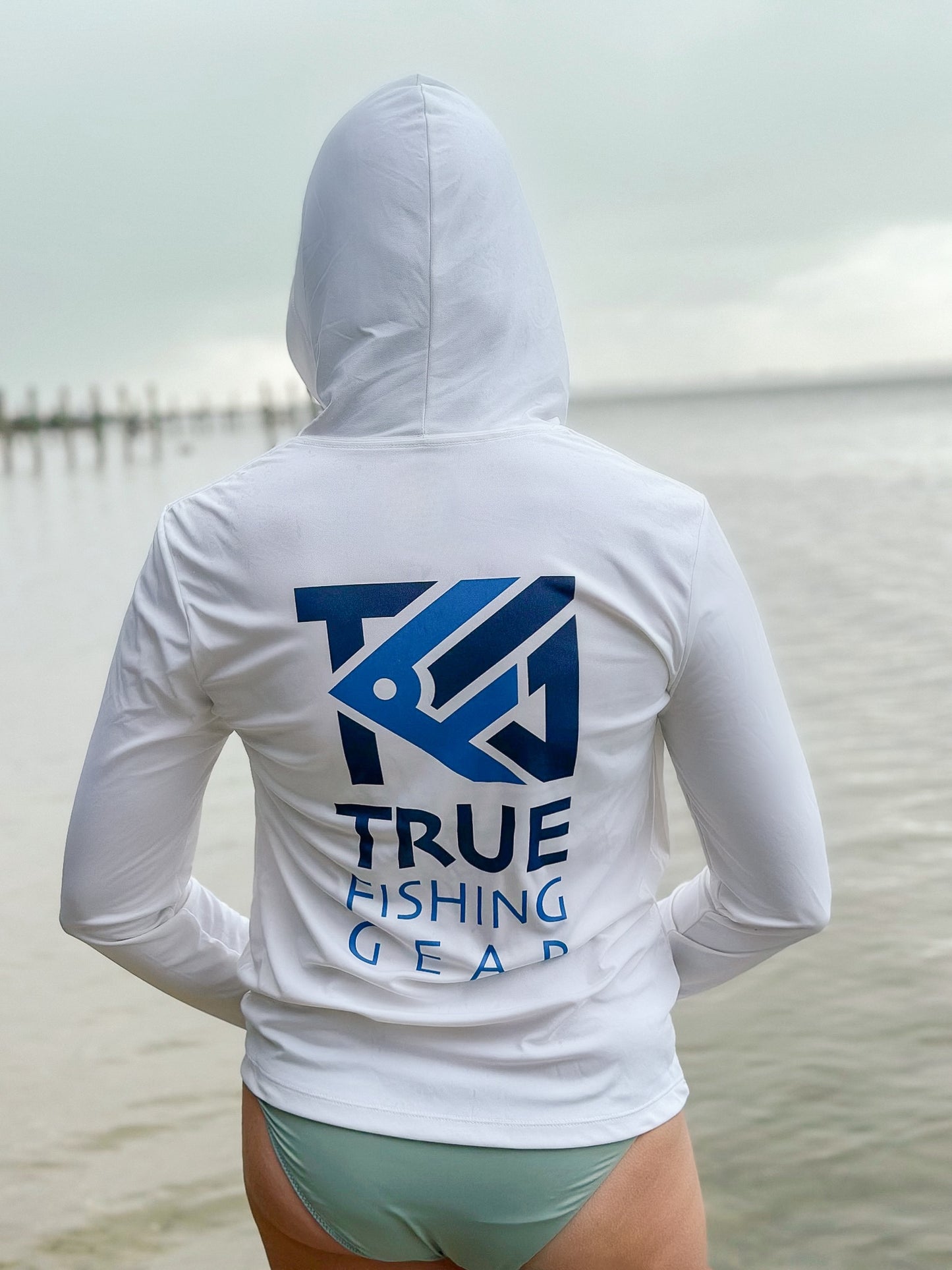 Rear view of woman wearing unisex hooded fishing shirt on beach