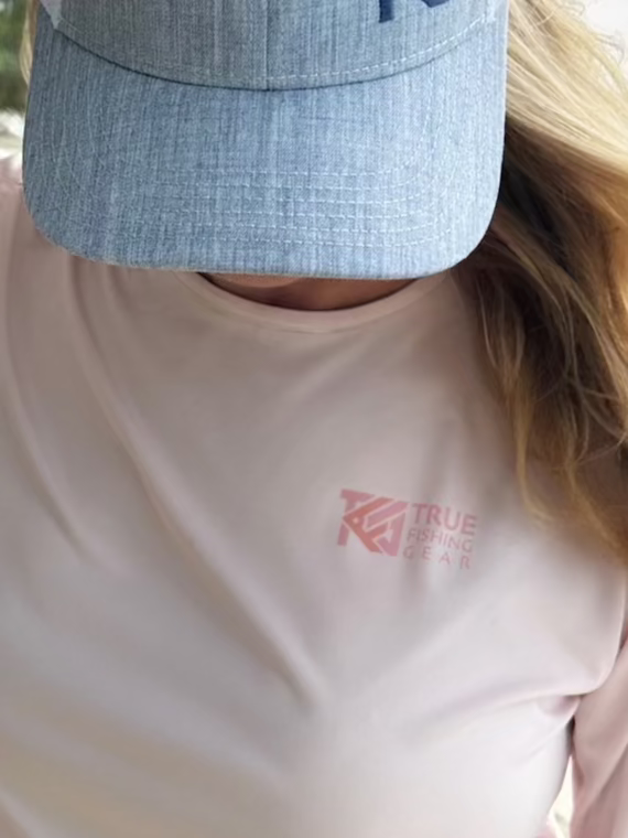 Woman wearing pink UPF fishing shirt on beach 