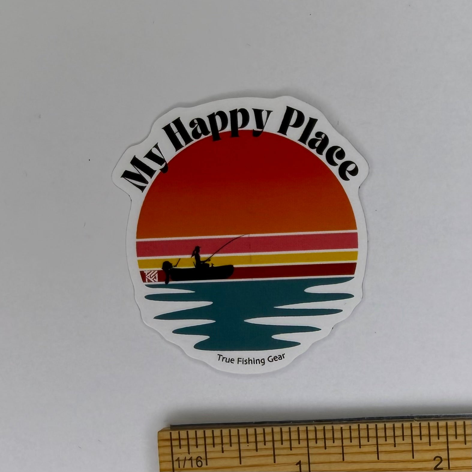 Sticker with 'My Happy Place' design featuring a sunset and fishing scene, on a white background.