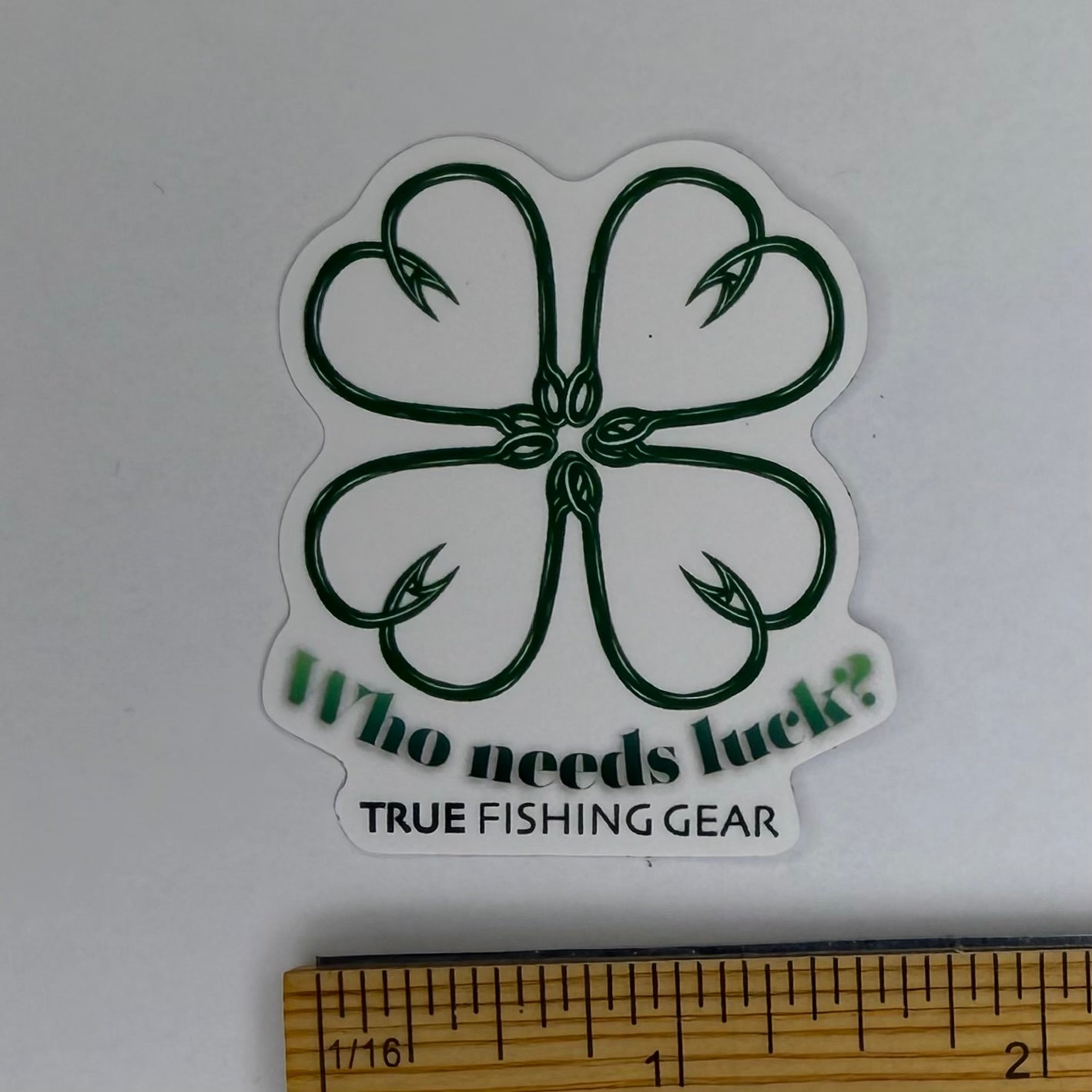 Sticker with fishing lure design and text 'Who needs luck? True Fishing Gear' on a white background.